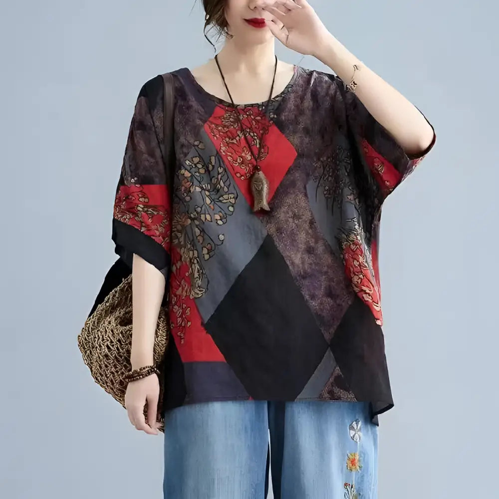 Stylish loose round neck printed patchwork blouse with dark geometric panels and intricate floral embroidery