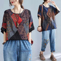 Stylish loose round neck printed patchwork blouse with bold geometric panels in deep blue rust red and brown tones with floral embroidery