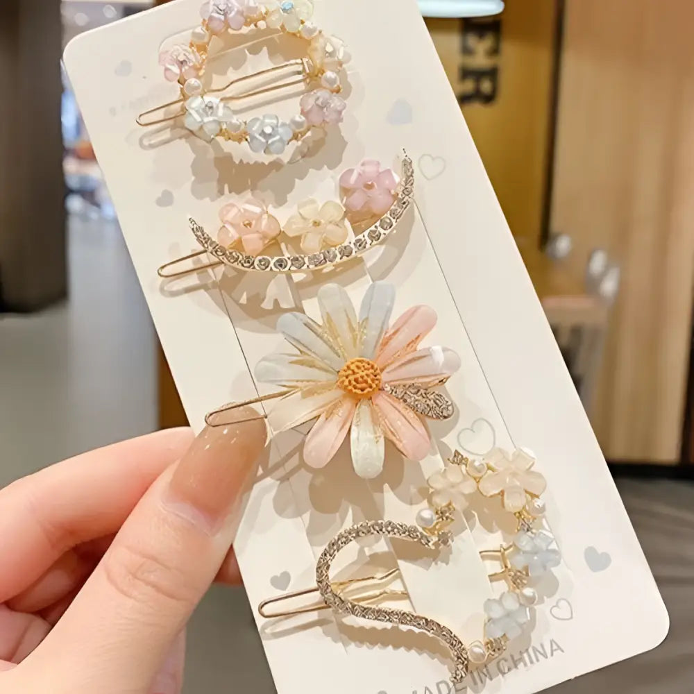 A set of five alloy handmade petal hair clips in pastel pink adorned with pearls and rhinestones on a white card