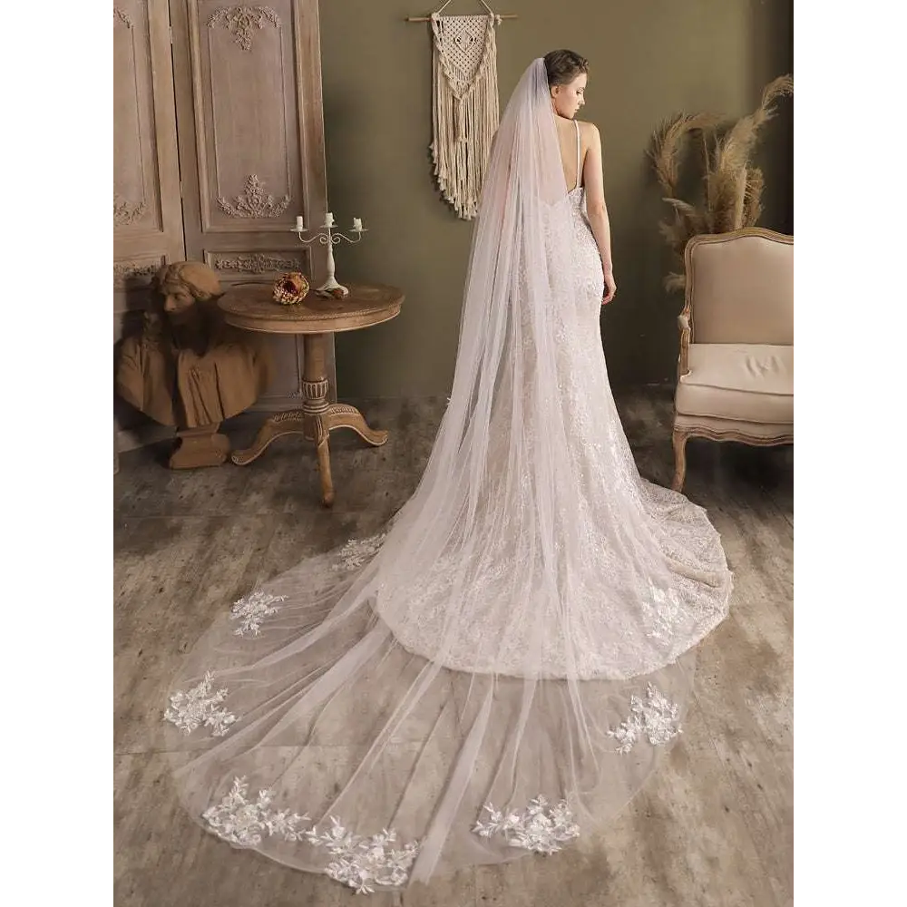 A flowing white lace flower trailing wedding gown with fitted bodice and floral embroidery in super fairy long style