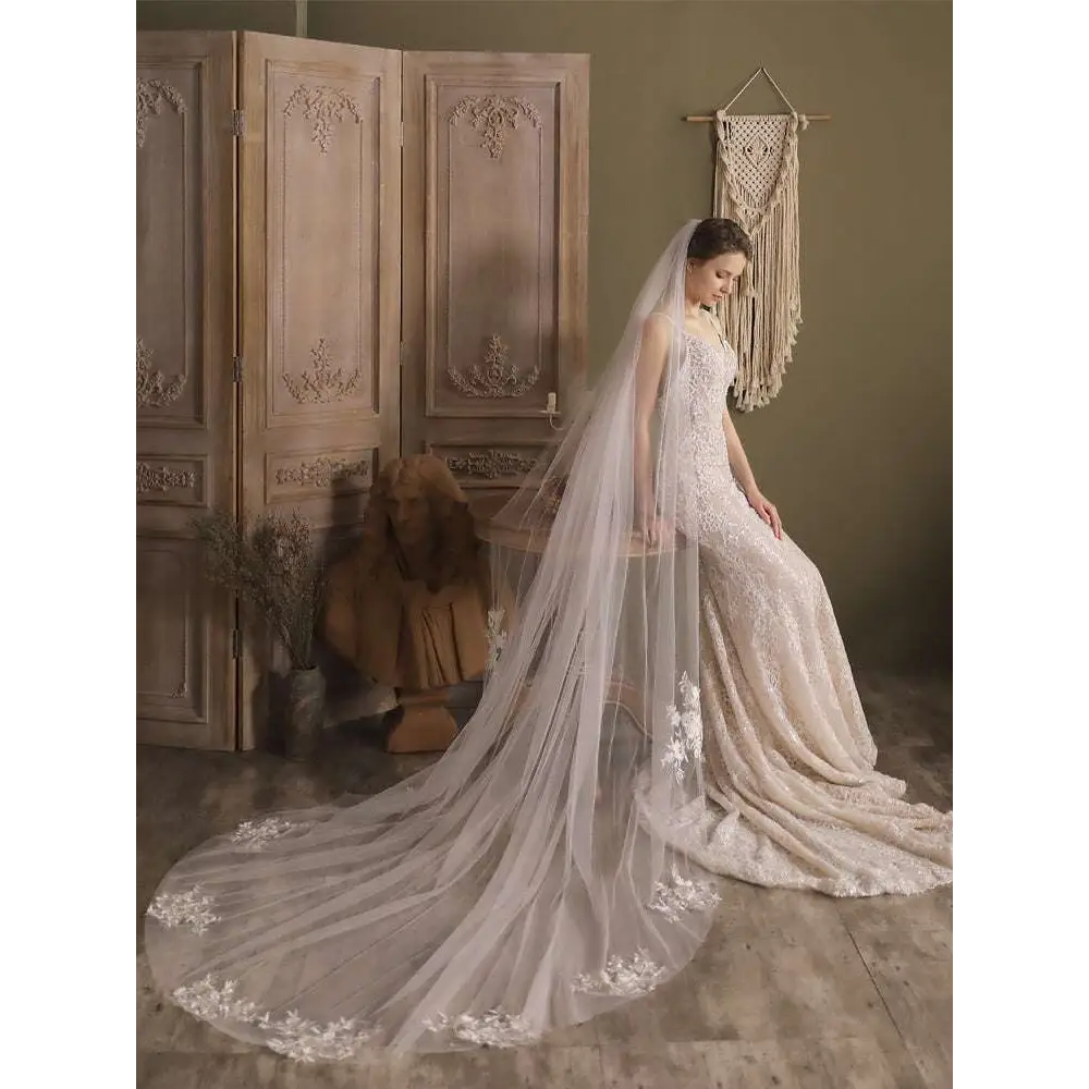 A flowing ivory lace flower trailing wedding veil with delicate floral embroidery on the back for the super fairy long gown