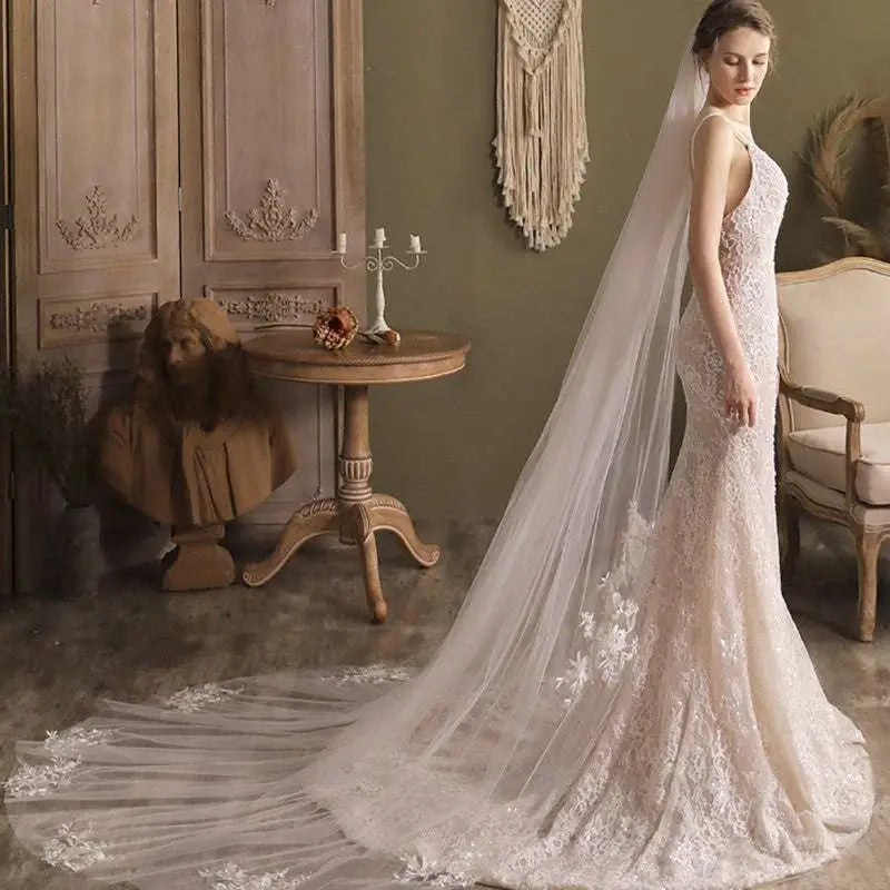 A flowing ivory lace wedding gown with super fairy long lace flower trailing and intricate floral embroidery details