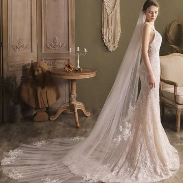 A flowing ivory lace wedding gown with super fairy long lace flower trailing and intricate floral embroidery details