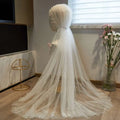 A flowing white bridal hijab adorned with delicate pearls along edges and crown in a super fairy long pearl veil style