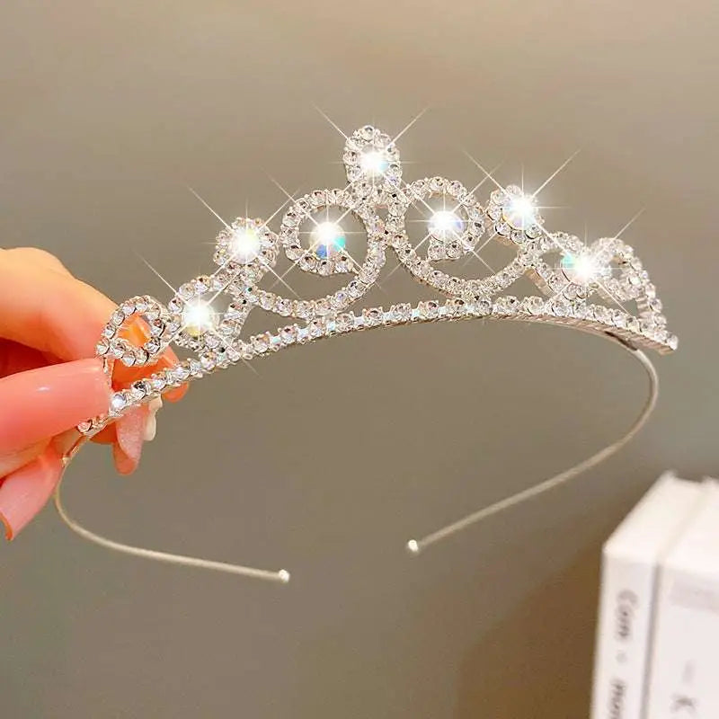 A sparkling silver crown headband with clear crystals and intricate metalwork from sweet fashion jewelry