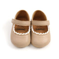 Tan leather baby princess shoes with beige mary jane style, white scalloped trim, and soft leather strap for infants