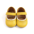 Tan leather baby princess shoes in bright yellow with white scalloped trim and velcro strap for easy wear