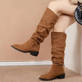Tan slouchy sleeve suede high leg boot featuring knee-high length and black block heels in soft tan suede