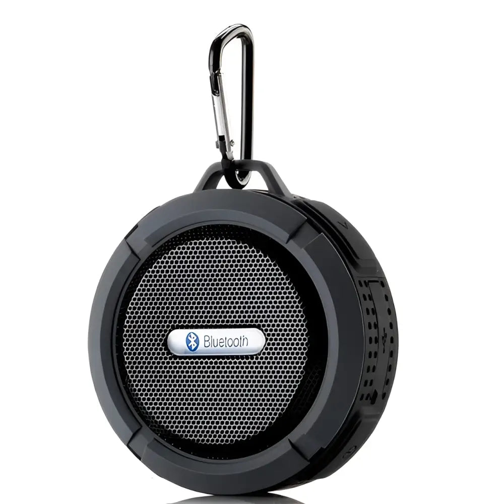 Black portable waterproof speaker with carabiner clip and perforated grille for outdoor use in luxury women’s fashion settings