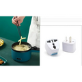 White plastic universal travel adapter with multiple plugs paired with teal compact multifunctional electric cooking pot