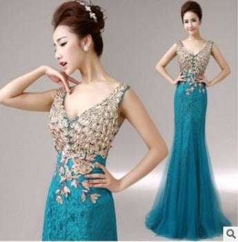 Teal mermaid-style evening gown with gold beaded and embroidered bodice perfect for bridal party wedding dress inspiration.