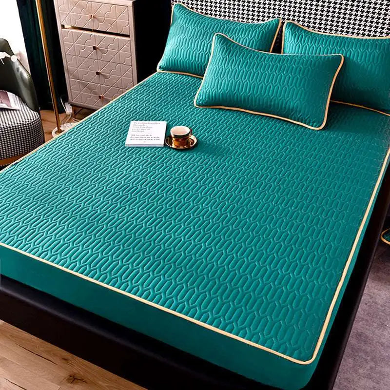 Teal quilted dust-proof single-piece fitted sheet with subtle geometric pattern and cream-colored piping edges