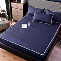 Navy blue quilted dust-proof single-piece fitted bed pad with white piping and subtle wave pattern for protection