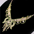An ornate green and clear rhinestone american exaggerated necklace with flowing designs in a butterfly jewelry set