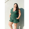 A plus-size woman wears a teal ruffled deep v one-piece swimsuit with built-in bra suitable for hot spring boxer use