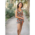 A vibrant orange and green floral print romper with ruched bodice and v-neckline featuring a built-in bra suitable for hot spring boxer use