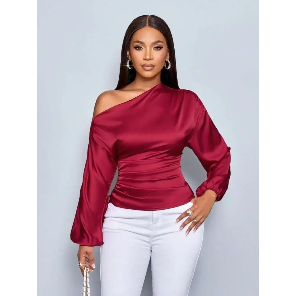 A sleek burgundy satin shirt asymmetric top with long sleeves and ruched waist detailing