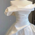 A white french satin gown with a fitted bodice and voluminous skirt in temperament princess style design