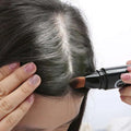 Black cylindrical color dye stick with brush applicator tip for temporary brown hair coloring use