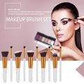 Ten piece makeup brush set with white handles gold ferrules black bristles arranged in a row with maroon case beauty complete kit