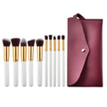 Ten piece makeup brush set with white handles gold ferrules dark brown bristles and a maroon case for beauty complete kit