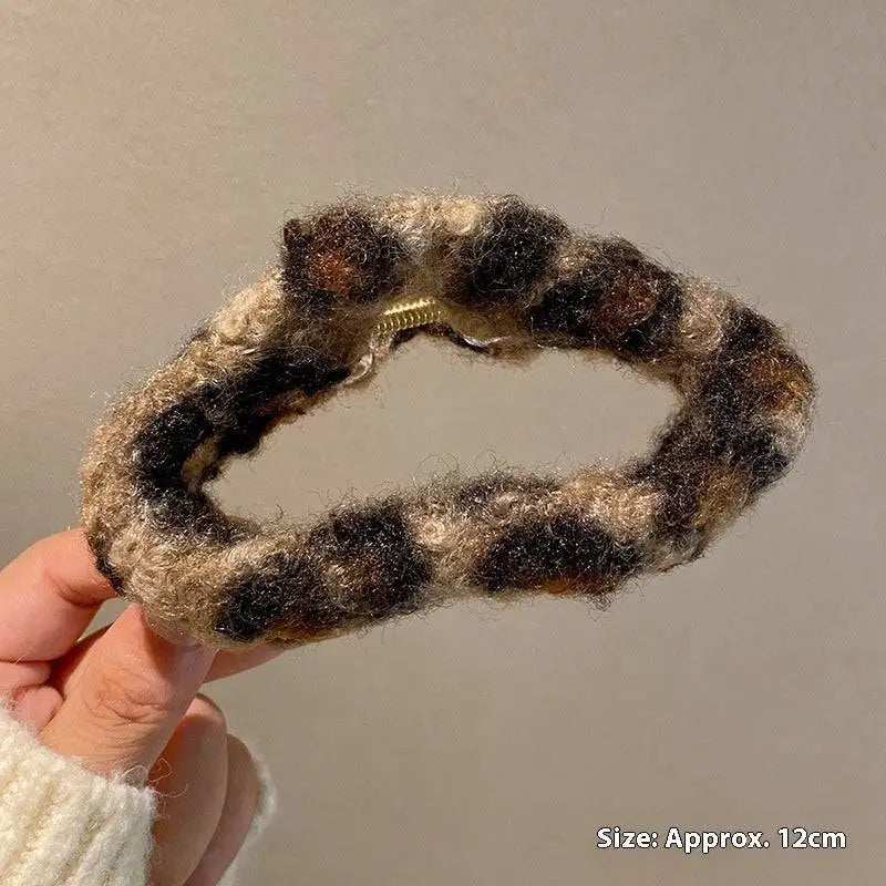 Cozy plush leopard bow hair clip with a textured winter plush chunky knit in black and beige tones