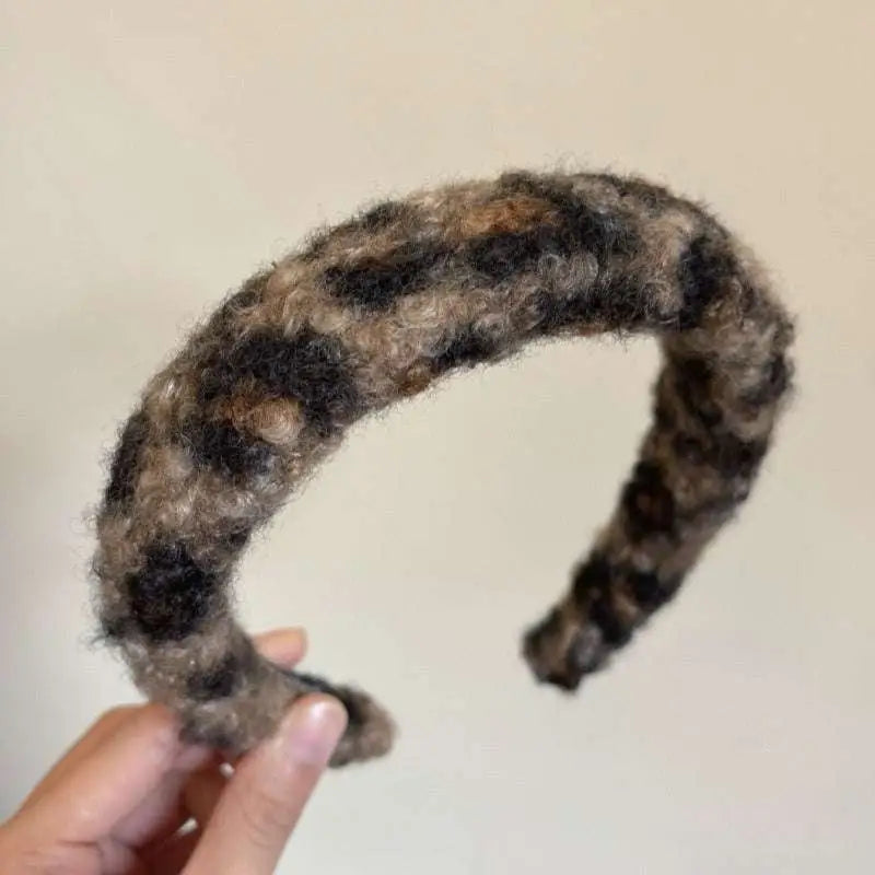 A cozy chunky knit headband in soft brown and black plaid paired with a textured winter plush leopard bow hair clip