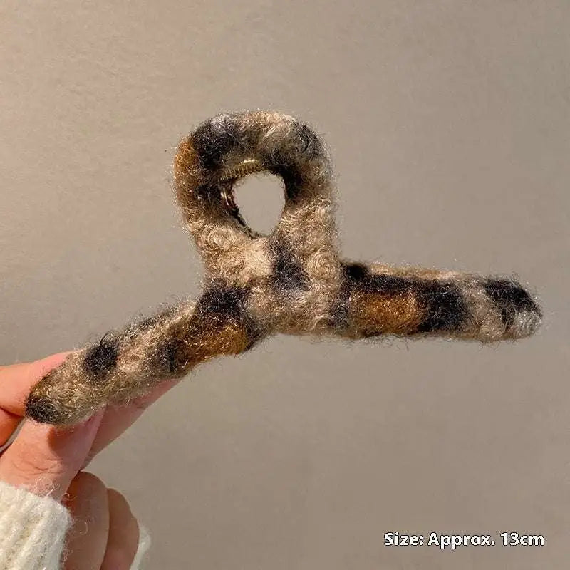 Textured winter plush bow hair clip in fuzzy brown and black plaid featuring a cozy plush leopard bow design