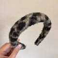 Textured winter plush black and gray plaid headband with a fuzzy texture complementing a plush leopard bow hair clip