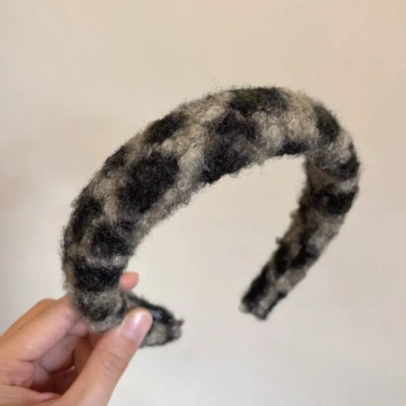 Textured winter plush black and gray plaid headband with a fuzzy texture complementing a plush leopard bow hair clip