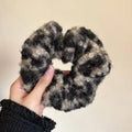A cozy chunky knit scrunchie in mottled black and gray inspired by textured winter plush bow hair clip designs