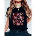 Black short-sleeved t-shirt with pink thick thighs and gloves vibes graphic print and heart accents
