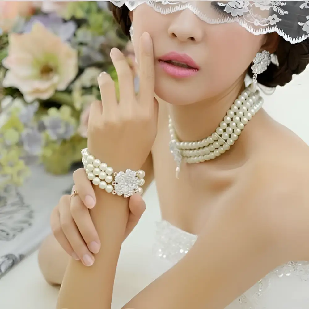 Pearl bracelet with central crystal embellishment complementing the silver three-piece four-leaf clover necklace set