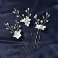 Three sets of white flower u shaped hairpins with elegant pearls and clear crystals on silver wire stems