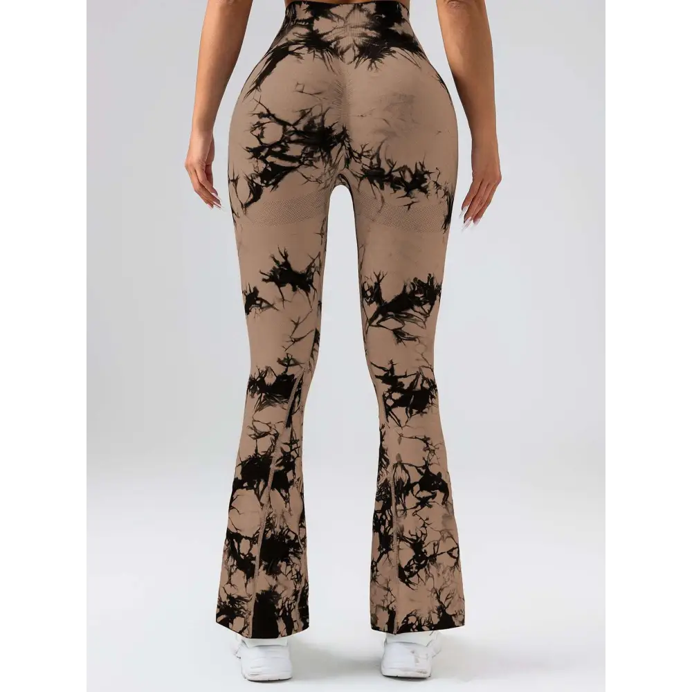 Back view of tan and black tie dye tummy control flare yoga pants with mesh panel and butt lift design