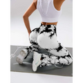 Back view of white and black tie dye tummy control flare yoga pants with mesh panel and butt lift design