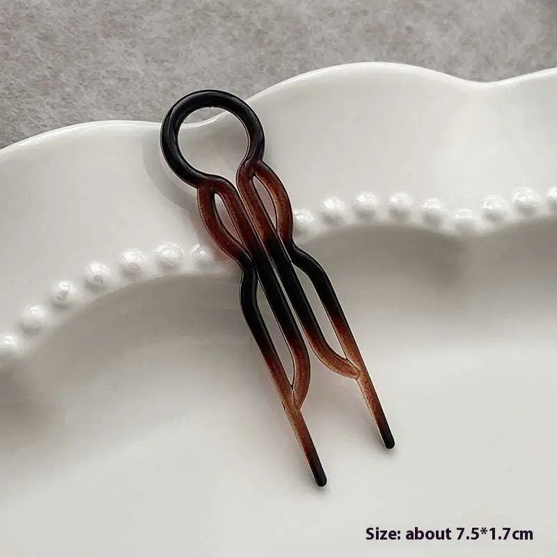A sleek gradient brown and black plastic tortoiseshell bun lazy updo gadget hair clip with a circular top loop