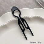 Black plastic phone card slotting tool with two elongated slots for tortoiseshell bun lazy updo gadget styling