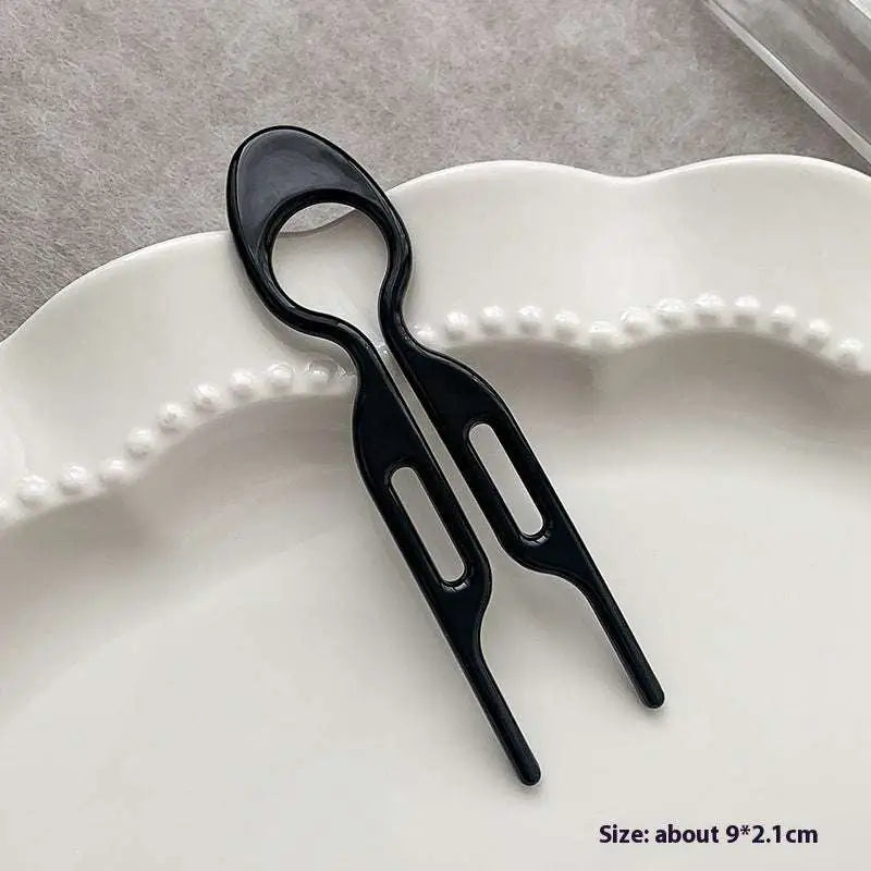 Black plastic phone card slotting tool with two elongated slots for tortoiseshell bun lazy updo gadget styling