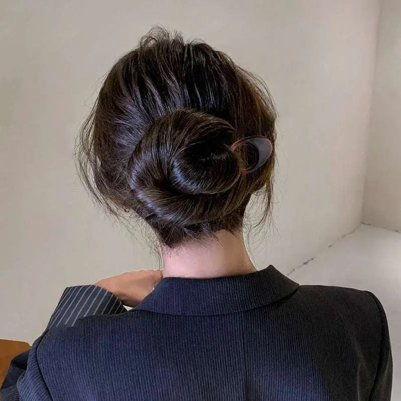 A sleek translucent black tortoiseshell bun lazy updo gadget hair clip with modern oval design holding a dark brown bun