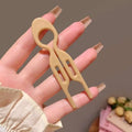 Beige plastic sim card removal tool with looped handle and two prongs for tortoiseshell bun lazy updo gadget styling