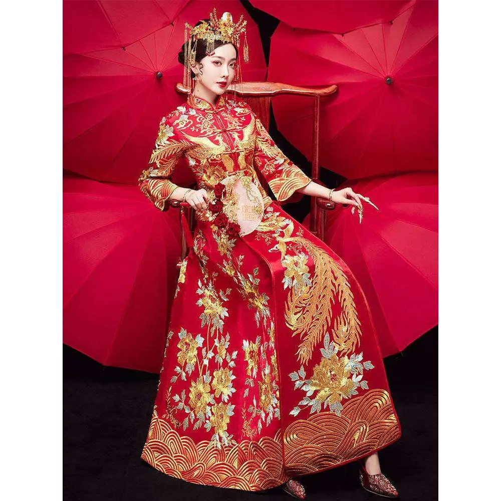 A woman wears a vibrant red robes xiuhe traditional chinese dragon wedding gown with gold and silver embroidery