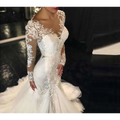 White mermaid-style long lace wedding dress with intricate lace detailing and long sheer sleeves trailing white temperament
