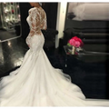 White mermaid-style long lace wedding dress with intricate lace detailing and long sheer sleeves trailing white temperament