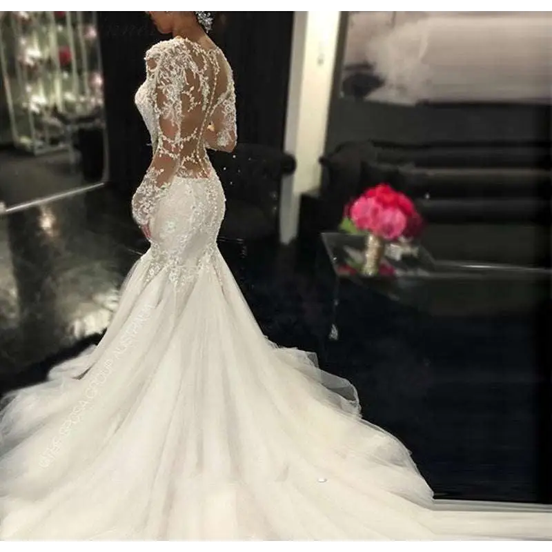 White mermaid-style long lace wedding dress with intricate lace detailing and long sheer sleeves trailing white temperament