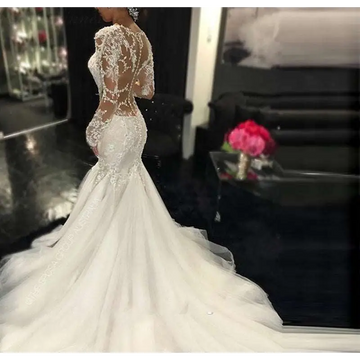 White mermaid-style long lace wedding dress with intricate lace detailing and long sheer sleeves trailing white temperament