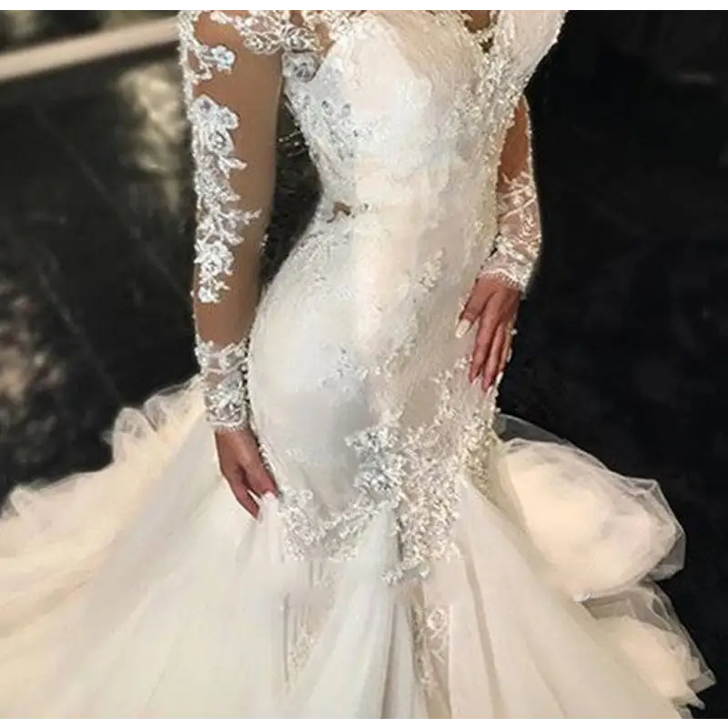 A white trailing white temperament long lace wedding dress with sheer lace sleeves and intricate beaded embroidery