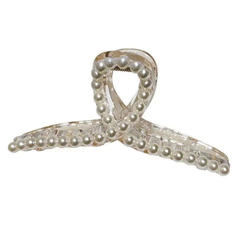 Transparent pearl grab clip made of clear acrylic adorned with small white pearls and a rhinestone bow detail