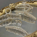 Transparent pearl grab clip made of clear acrylic adorned with small white pearls and a rhinestone bow