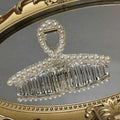 Clear acrylic pearl grab clip with white pearls and a rhinestone bow decoration for elegant hair styling